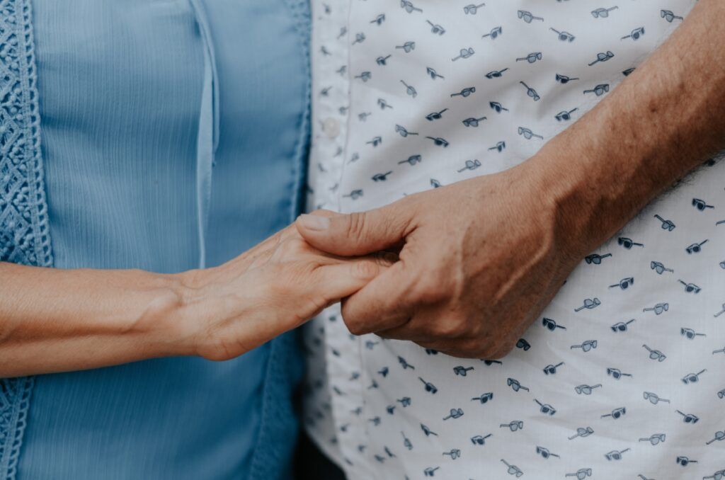 Older couple holding hands because they are happy they have their health care documents in place.