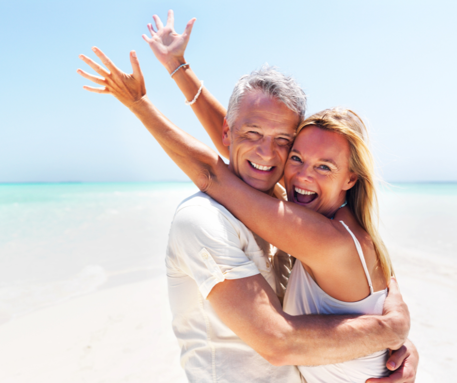 Happy couple on beach enjoying their retirement as new empty nesters