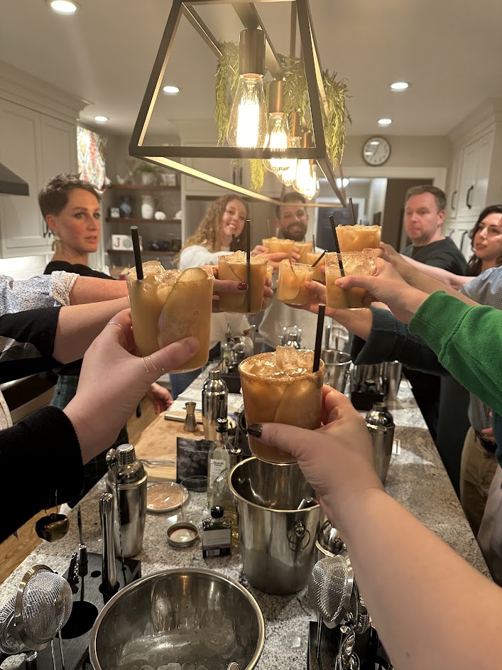 Group of happy estate planners cheering their cocktails at a their Christmas party.