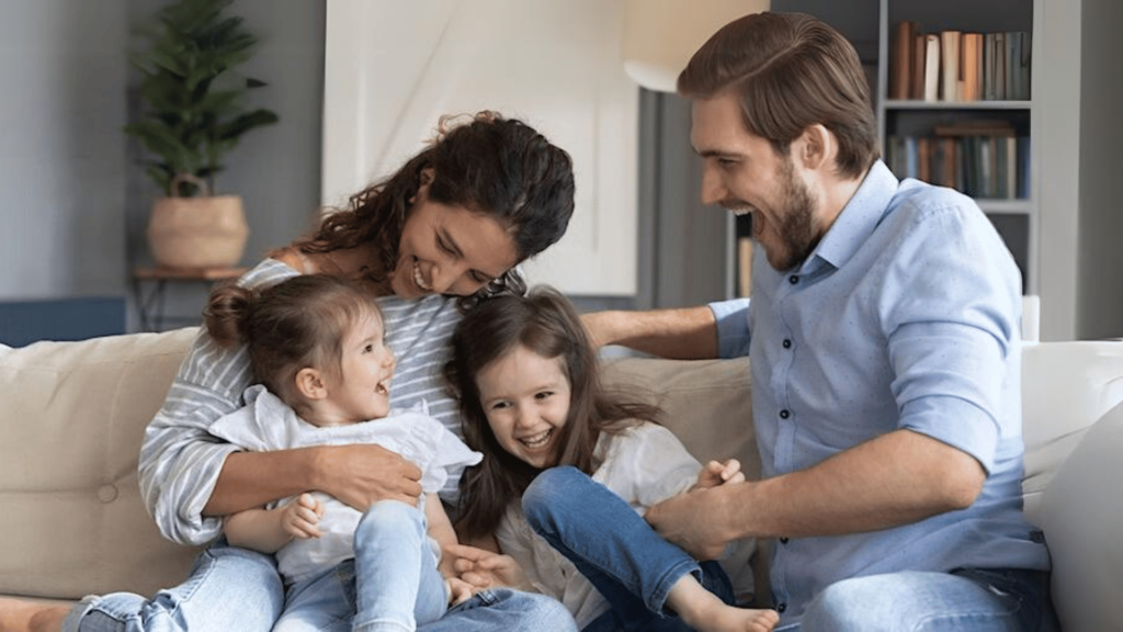 Young family happily playing on the couch, at peace knowing they have their estate plan for young families.