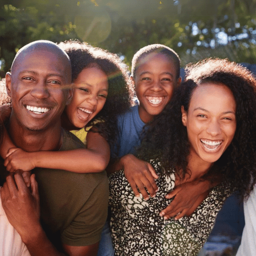 A secure family smiling on a beautiful day, knowing their kids protection planning guide is keeping their kids safe.